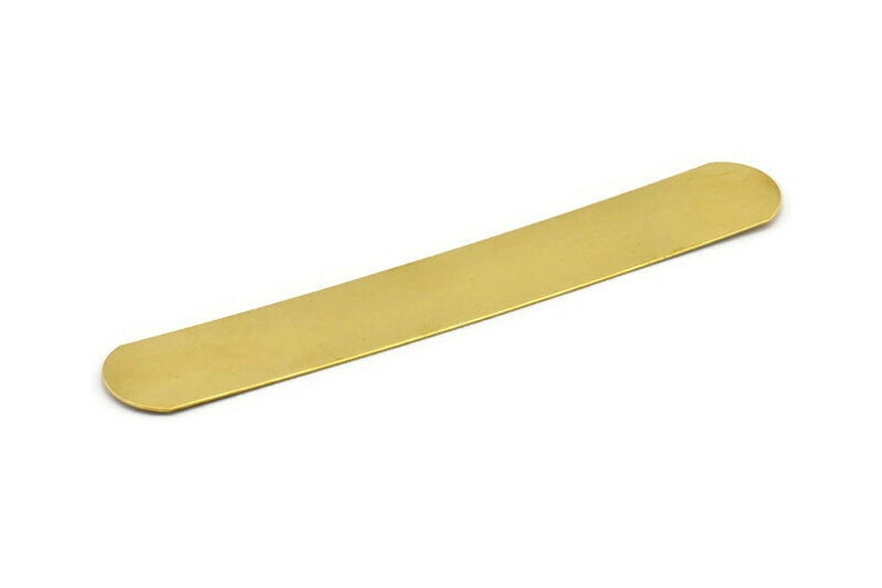 Op de afbeelding: Een lange, dunne, platte, gouden metalen bladwijzer met afgeronde uiteinden.
