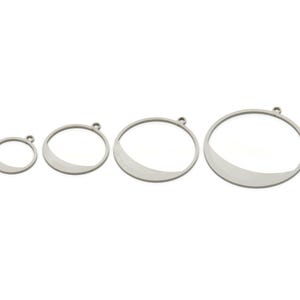 May include: Four silver metal hoops of varying sizes, each with a half-circle cut out. The hoops have a smooth, polished finish.