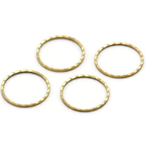 May include: Four gold-coloured metal rings with a hammered texture. The rings are circular and have a slightly irregular, textured surface. They are set against a white background, highlighting their metallic sheen. These rings are suitable for jewellery making.