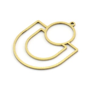 May include: Gold metal pendant with a geometric design featuring a circle and two curved lines. The pendant has a hole at the top for attaching a chain or cord.