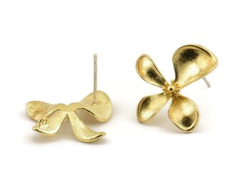 May include: A pair of gold-tone earrings, one shaped like a bow and the other shaped like a flower.