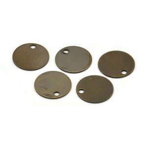May include: Five antique gold-toned metal round disc charms with a small hole in the center of each disc.