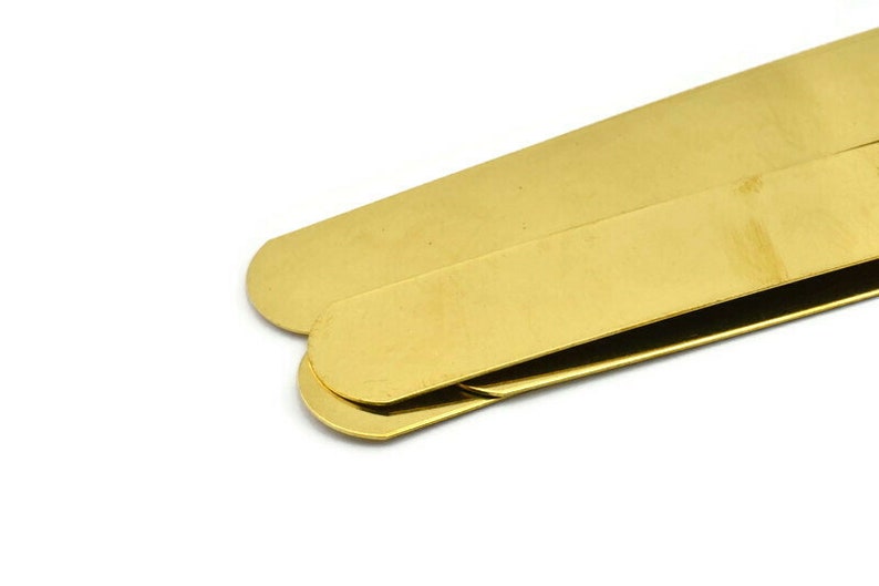 Op de afbeelding: Twee gouden metalen geldclips op elkaar gestapeld.