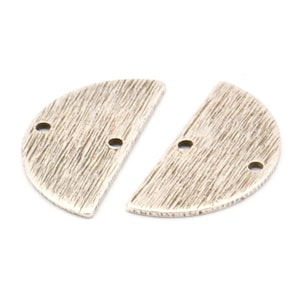 May include: Two silver-coloured, half-circle shaped metal jewellery components. Each piece has a textured surface with two small holes for attaching. Suitable for jewellery making or craft projects.