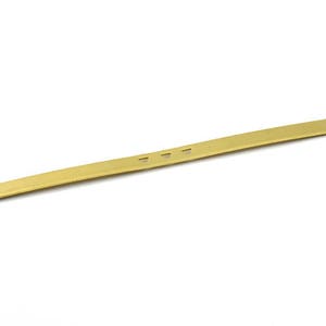 Può includere: Una barra di metallo color oro con tre piccoli fori al centro.