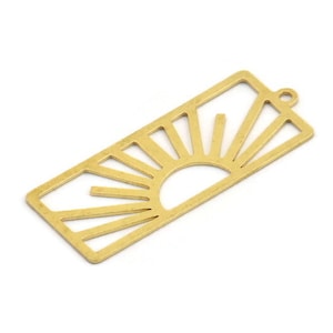 May include: Gold-toned metal charm with a cutout design of a sun with rays. The charm has a rectangular shape with rounded corners.