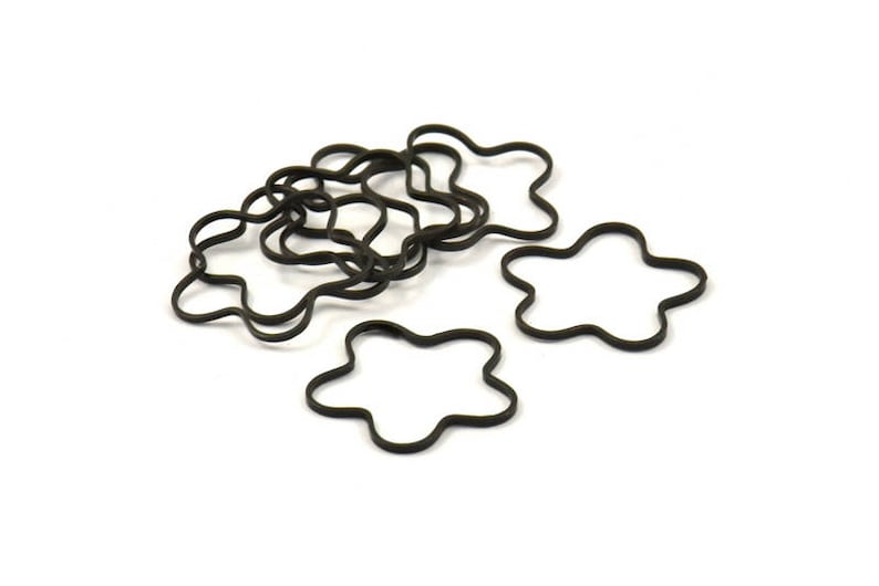 May include: A set of black rubber hair ties shaped like five-pointed stars. The hair ties are arranged in a pile, with some of them overlapping.