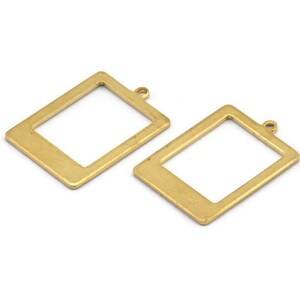 May include: Two gold-toned metal picture frame charms with a square shape and a small loop at the top for hanging.