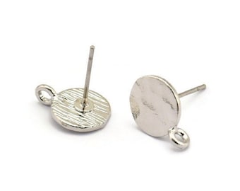 May include: Two silver earring blanks with a round, flat surface and a small loop on the side. The earring posts are attached to the back of the blanks.