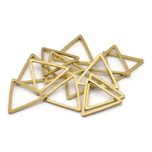 Puede incluir: Un mont&oacute;n de anillos de metal de forma triangular de color dorado. Los anillos son todos del mismo tama&ntilde;o y forma, y est&aacute;n dispuestos en un patr&oacute;n aleatorio.