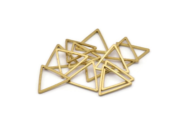 Puede incluir: Un mont&oacute;n de anillos de metal de forma triangular de color dorado. Los anillos son todos del mismo tama&ntilde;o y forma, y est&aacute;n dispuestos en un patr&oacute;n aleatorio.