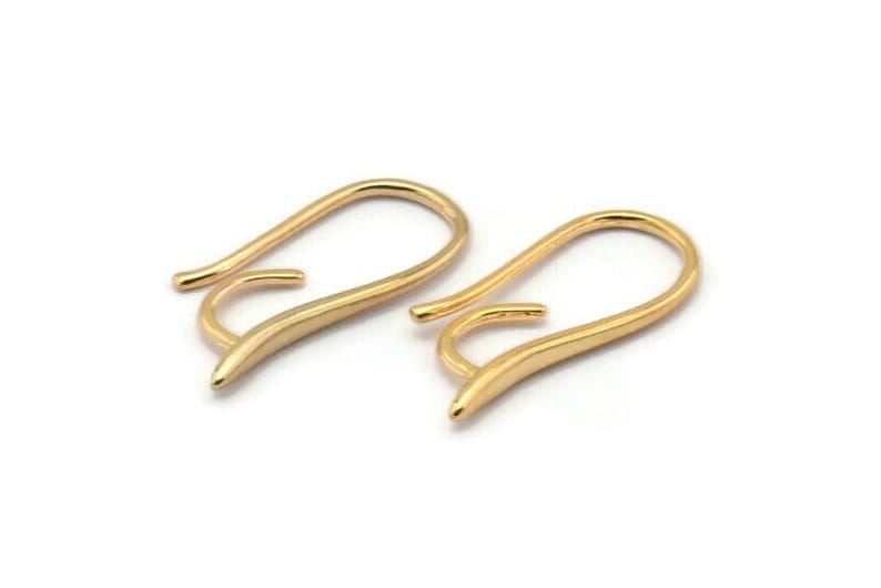 May include: A pair of gold-toned earring hooks. The hooks are made of a smooth, curved metal and have a simple, elegant design.