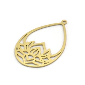 May include: Gold-toned metal pendant with a cutout design of a lotus flower. The pendant is shaped like a teardrop and has a loop at the top for attaching a chain.