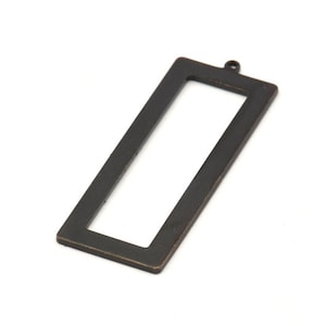 May include: A black metal rectangular frame with a small loop at the top. The frame is designed to hold a photo or other small object.