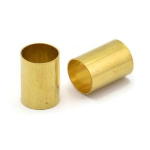 May include: Two gold-colored metal tubes, each with a smooth, cylindrical shape. The tubes are approximately 1 inch in diameter and 1 inch in height.