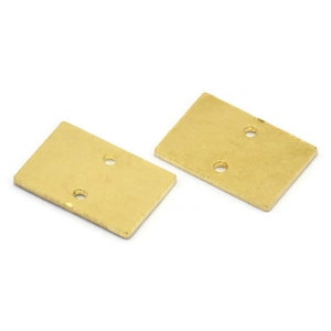 Pode incluir: Duas placas retangulares de metal de cor dourada com dois furos cada.