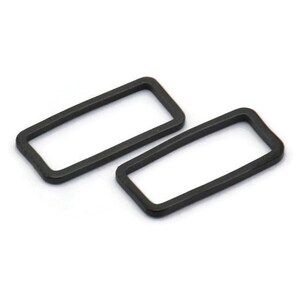 Puede incluir: Dos anillos rectangulares de metal negro, posiblemente para sujetar a un llavero o una bolsa.