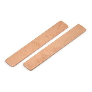 May include: Two long, thin, rectangular pieces of copper metal. The metal has a hammered, textured finish and is a warm, reddish-brown color.