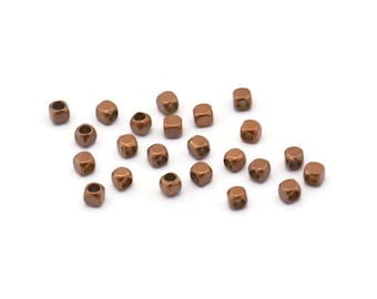 May include: A scattering of small, copper-colored metal beads, each with a square shape and a hole in the center.