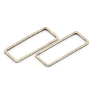 May include: Two silver-toned metal rectangular rings, each with a slightly irregular shape.