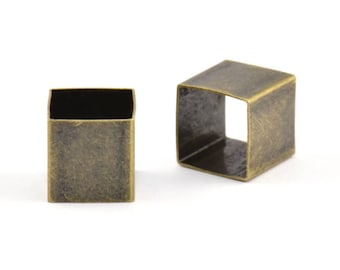 May include: Two antique gold square metal rings with a square hole in the center.