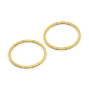 May include: Two gold-colored metal rings, each with a circular shape and a smooth, polished finish.