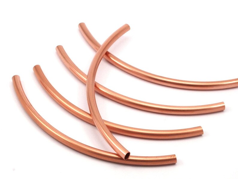 May include: Five copper wire hoops, each bent into a semi-circle shape. The hoops are stacked on top of each other, with the largest hoop at the bottom and the smallest hoop at the top.