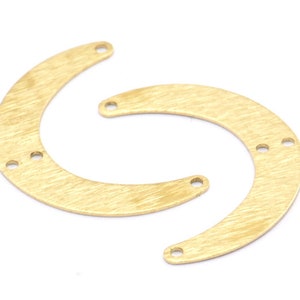 May include: Two gold-colored metal crescent shapes with holes for attaching jewelry findings. The crescent shapes have a brushed finish.