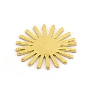 May include: A gold-colored metal sunburst charm with a circular center and radiating points.