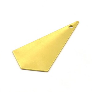 Pode incluir: Um pingente de metal dourado em forma de triângulo com bordas arredondadas e um pequeno furo no topo.
