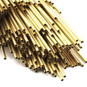 May include: A bundle of shiny gold brass tubing, arranged in a fan shape. The tubing is smooth and has a consistent diameter.