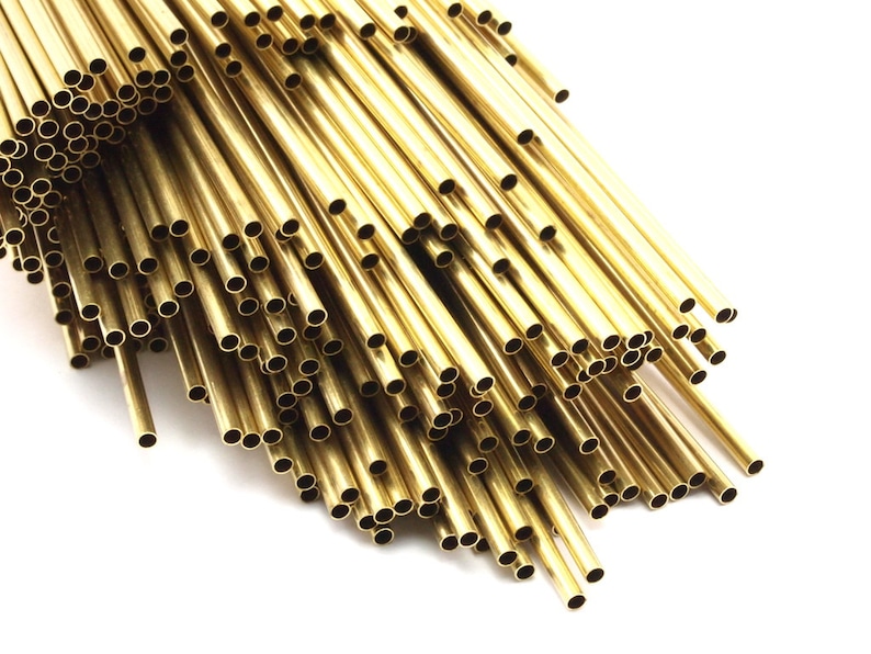 May include: A bundle of shiny gold brass tubing, arranged in a fan shape. The tubing is smooth and has a consistent diameter.