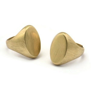 May include: Two gold oval signet rings with a brushed finish.