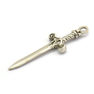 May include: A silver sword charm with a twisted handle and a detailed hilt.