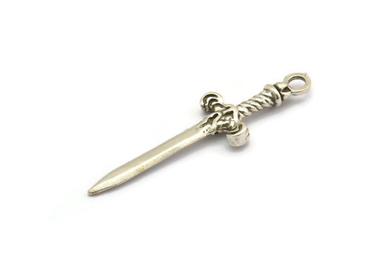 May include: A silver sword charm with a twisted handle and a detailed hilt.