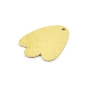 May include: Gold-colored metal charm shaped like a stylized heart with a small hole at the top.