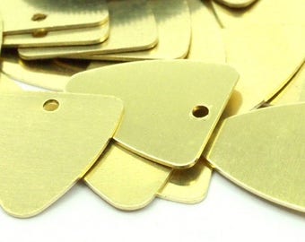 May include: A pile of brass triangle-shaped charms with a hole in the top. The charms are a light gold color and have a smooth, polished finish.
