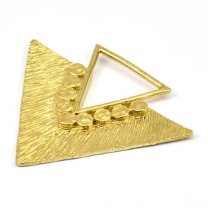 May include: Gold triangle pendant with a textured surface and a smaller triangle cutout. The pendant is decorated with a row of small, round, gold beads.