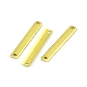 May include: Three gold-colored metal bar connectors with two holes each. The bars are flat and rectangular.