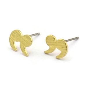 May include: A pair of gold-toned earrings shaped like quotation marks. The earrings have a brushed finish and are made of metal.
