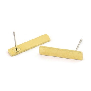 Könnte beinhalten: Ein Paar goldfarbene rechteckige Ohrstecker mit schlichtem Design. Die Ohrringe haben einen Stift und einen Schmetterlingsverschluss.