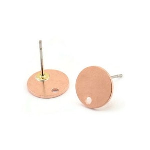 May include: A pair of rose gold round stud earrings with a small hole in the center of each earring. The earrings have a silver post and a gold backing.
