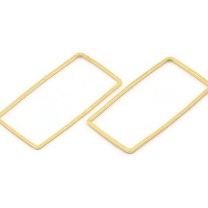 Puede incluir: Dos pendientes de aro rectangulares de color dorado. Los aros son simples y minimalistas en diseño.