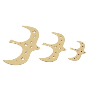 May include: Three gold-coloured, crescent-shaped metal charms. Each charm features star-shaped cutouts. The charms are in varying sizes, with the largest on the left and the smallest on the right.