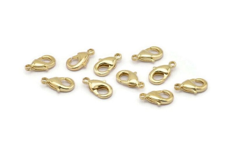 Peut inclure: Dix fermoirs &agrave; ressort dor&eacute;s, un type de fermoir utilis&eacute; pour la fabrication de bijoux.