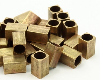 May include: A pile of brass-colored metal end caps, some with a square shape and some with a round shape.