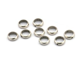 May include: Ten silver-toned metal rings with a small hole in the center of each ring. The rings are arranged in a scattered pattern on a white background.