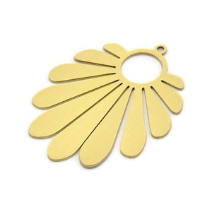 May include: Gold metal pendant with a sunburst design and a round hole in the center. The pendant is perfect for jewelry making.