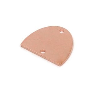 Puede incluir: Un componente de joyería de metal color cobre con forma redondeada y dos pequeños agujeros. La pieza tiene una superficie plana y lisa y una ligera curva a lo largo del borde inferior. Ideal para crear pendientes, colgantes u otras joyas.