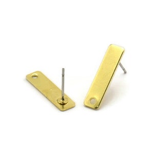 May include: Two gold-toned earring posts with rectangular metal plates. The plates have a hole at the top for attaching charms or other jewelry.